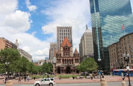 Low Angle View Of Trinity Church And Modern Glass Buildings In Front Of Road In City